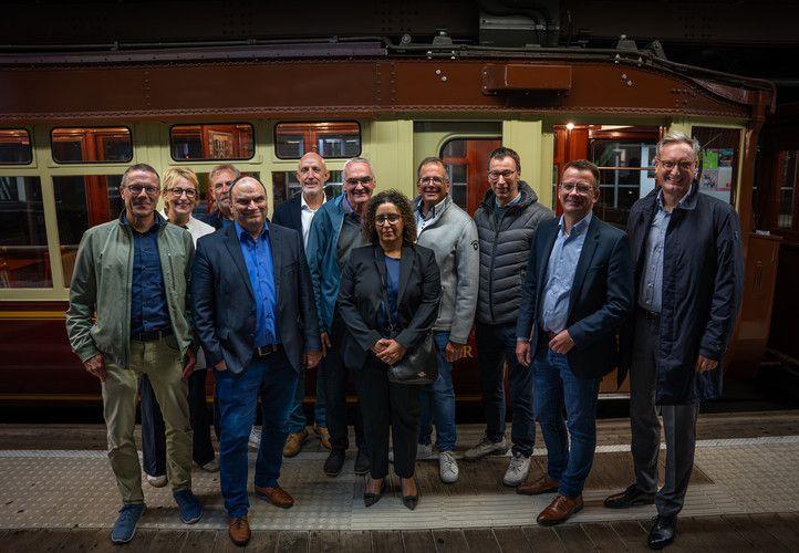 Die Ehrengäste der Testfahrt posieren am Bahnhof vor dem Kaiserwagen