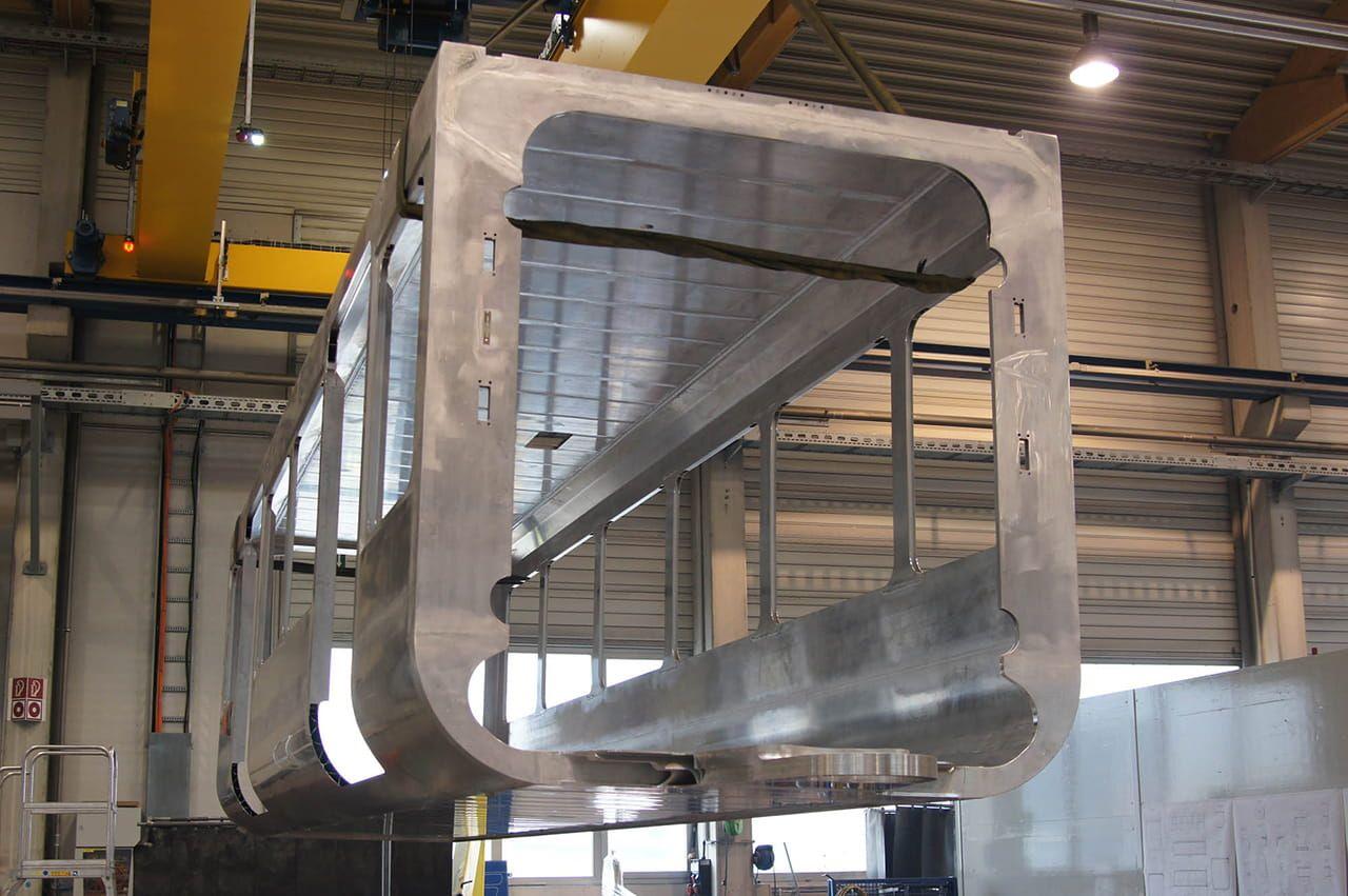 Der erste Wagenkasten aus Metall der neuen Schwebebahn Generation in der Fertigungshalle