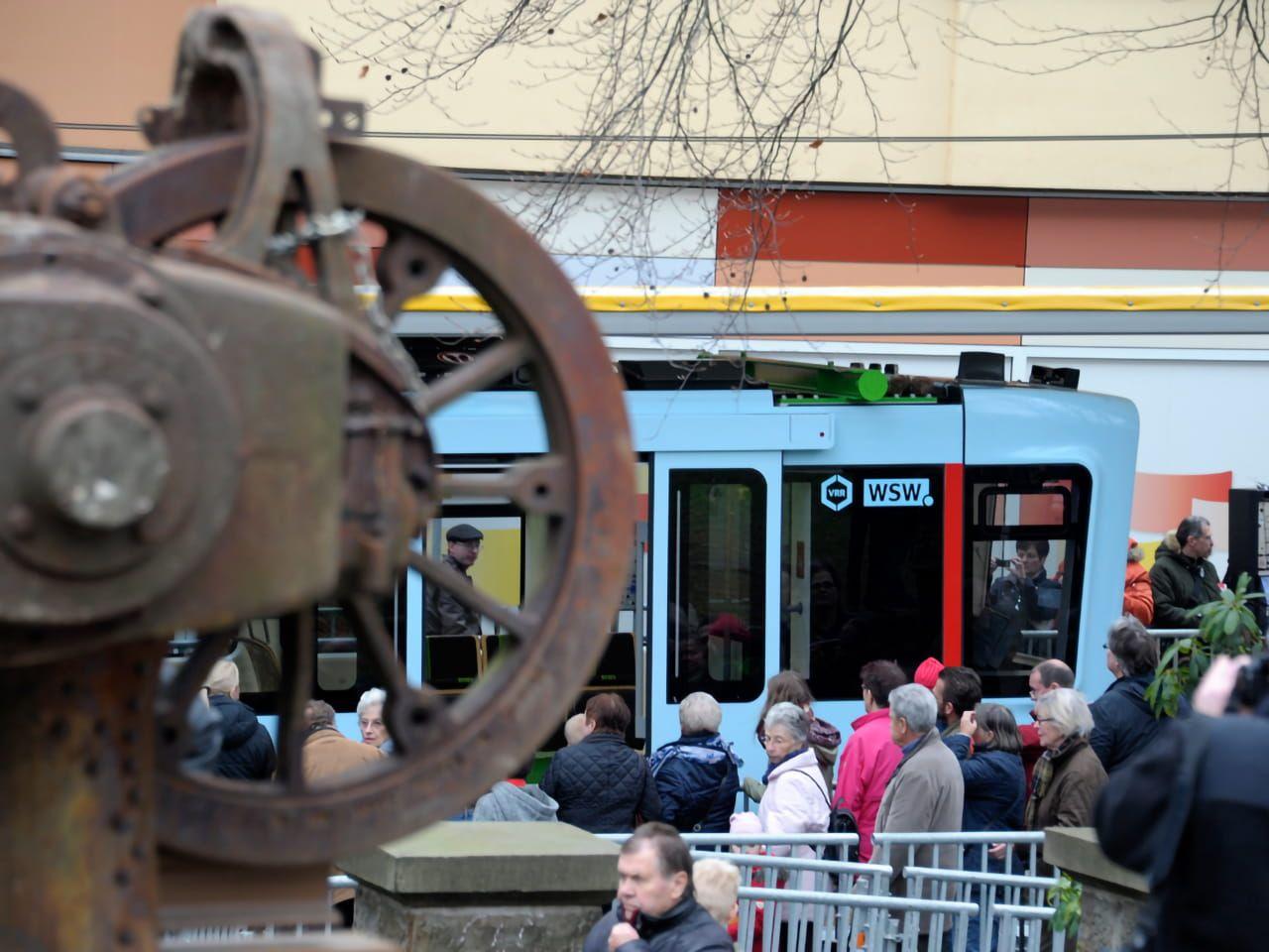 Ein altes Drehgestell im neu eröffneten Schwebebahnpark, im Hintergrund die nächste Schwebebahngeneration